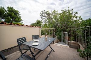una mesa azul y 2 sillas en el patio en Le Jasmin airconditioned studio with swimming pool en Marsella