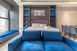 een slaapkamer met een blauwe bank voor een bed bij The Rixx Boutique- Opera House- SmartTV65in - pool in Ho Chi Minh-stad