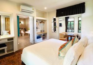 a bedroom with a white bed and a bathroom at Sirarun Resort in Ban Krut