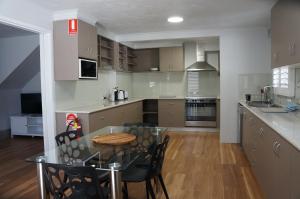 a kitchen with a table and chairs in a room at Waves Motel and Apartments in Warrnambool