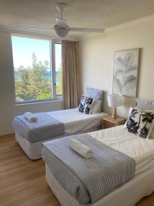 Habitación de hotel con 2 camas y ventana en Oceania on Burleigh Beach en Gold Coast