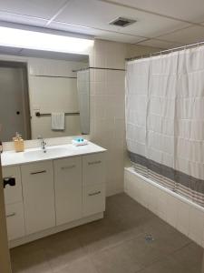 a bathroom with a sink and a mirror and a shower at Oceania on Burleigh Beach in Gold Coast