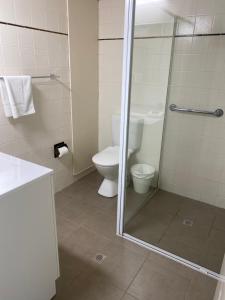 a bathroom with a toilet and a glass shower at Oceania on Burleigh Beach in Gold Coast