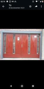 グアレグアイチュにあるDEPTO Familiarの赤いドア付きの窓