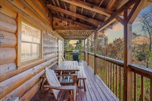 a porch of a cabin with chairs and a table at Five-Bedroom House in Sevierville