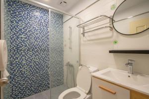 a bathroom with a shower and a toilet and a sink at Kenting Shin Yu Homestay in Kenting