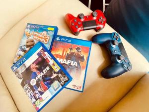 a nintendo wii game controller next to a video game at Trendy Family Getaway by StayCo - Mini-Pool, Outdoor Cinema, Air Loft, PS4, KTV - Just 2 mins to Beach! in Batu Ferringhi