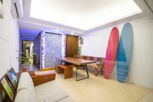 a room with a table and surfboards on the wall at Kenting Shin Yu Homestay in Kenting