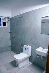 a bathroom with a toilet and a sink at EMFORE ELANZA in Kottayam