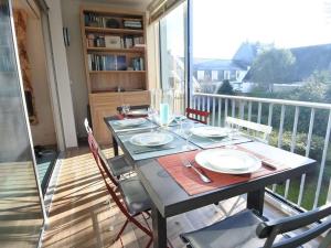 a dining room table with a view of a balcony at Appartement La Trinité-sur-Mer, 4 pièces, 6 personnes - FR-1-477-178 in La Trinité-sur-Mer