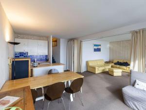 een keuken en woonkamer met een tafel en een bank bij Grand studio lumineux pour 6 pers, centre station, proche pistes - FR-1-404-342 in La Mongie