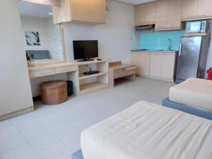um quarto com uma cozinha com uma televisão e um sofá em Posh Beds with City View and Pools em Manila