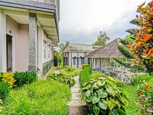 einen Garten vor einem Haus mit Pflanzen in der Unterkunft OYO 92023 Singgasana Cipelah Syariah in Garut