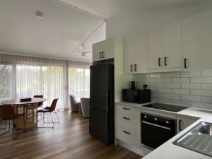 eine Küche mit einem schwarzen Kühlschrank und einem Tisch in der Unterkunft Selah Valley Estate in Limpinwood