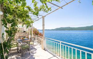 a balcony with a table and chairs and a view of the water at Stunning Home In Slano With 3 Bedrooms And Wifi in Slano