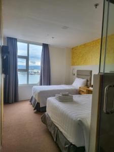 ein Hotelzimmer mit 2 Betten und einem großen Fenster in der Unterkunft Sempre Premier Inn - MACTAN AIRPORT HOTEL in Mactan