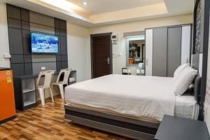 um quarto com uma cama grande e uma televisão em The Ring Residence em Hat Yai