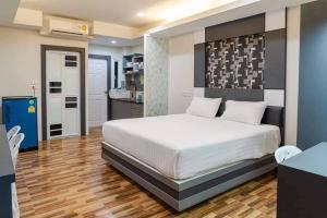 a bedroom with a large bed and a kitchen at The Ring Residence in Hat Yai