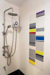a shower in a bathroom with a colorful wall at The Ring Residence in Hat Yai