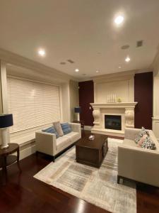 a living room with two couches and a fireplace at Grand House in Westside Vancouver in Vancouver