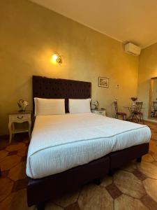 1 dormitorio con 1 cama grande con sábanas blancas en Guest House Le Contesse, en Florencia