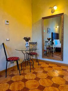 mesa y sillas en una habitación con espejo en Guest House Le Contesse, en Florencia
