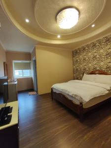 1 dormitorio con 1 cama y techo con TV en Niuge Minsu Homestay en Yuli