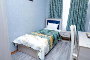 a small bedroom with a bed and a desk at RamRamay in Qax
