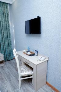 a room with a desk with a tv on a wall at RamRamay in Qax