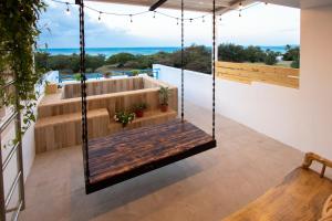 a swing on a balcony with a view of the ocean at Kenting Shin Yu Homestay in Kenting