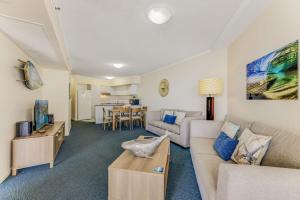 a living room with a couch and a table at Grand Pacific Unit 112 Caloundra QLD in Caloundra