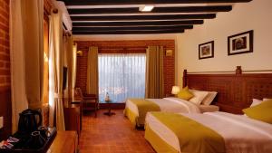 a hotel room with two beds and a window at Soaltee Westend Resort Nagarkot in Nagarkot