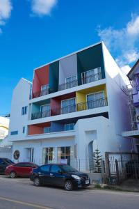 un edificio con coches estacionados frente a él en Grow home -Stay and space, Self check-in, en Chiang Rai