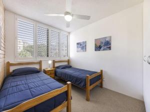 deux lits dans une chambre avec deux fenêtres dans l'établissement Jamarkos Unit 4 Kings Beach QLD, à Caloundra 7 autres photos