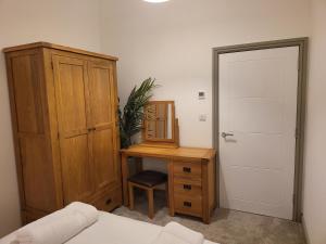 a bedroom with a desk with a mirror and a cabinet at Impeccable 1-Bed Apartment in Buxton Town Center in Buxton