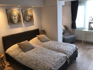 1 dormitorio con 1 cama con 3 cuadros en la pared en 't Molentje, en Zandvoort
