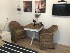 a room with a table with two chairs and a tv at Pension Hendriks in Zandvoort