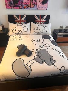 a bed with a mickey mouse comforter on it at Prospect House in London