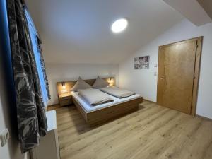 1 dormitorio pequeño con 1 cama y suelo de madera en Cozy apartment in Wald im Pinzgau with balcony and barbecue area en Wald im Pinzgau