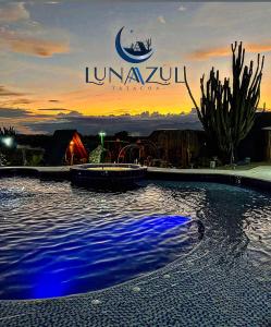 a swimming pool with a sunset in the background at Hotel Luna Azul Tatacoa in Villavieja