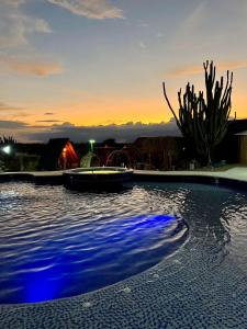 a pool with blue lights in the water at sunset at Hotel Luna Azul Tatacoa in Villavieja +44 photos