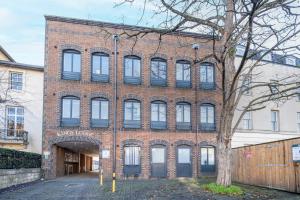 un edificio de ladrillo con un árbol delante de él en Reading Town Centre 1 & 2 Bedroom Apartments with Parking by 360Stays, en Reading