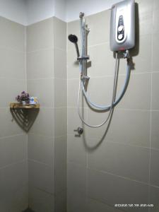 a shower in a bathroom with a hose at Armada Sweet Homestay in Gua Musang