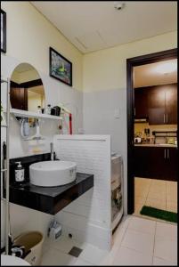 een badkamer met een witte wastafel en een spiegel bij A Refreshing Condo Unit Near BGC, Ortigas & Makati with NETFLIX and WiFi in Manilla
