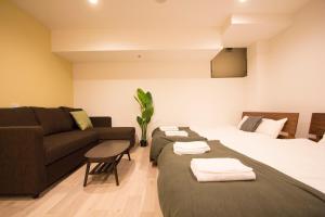 - un salon avec deux lits et un canapé dans l'établissement SEVEN Building / Vacation STAY 4943, à Asahikawa