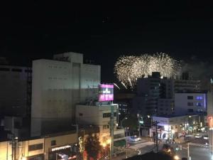 une ligne d'horizon avec feux d'artifice en arrière-plan la nuit dans l'établissement SEVEN Building / Vacation STAY 4959, à Asahikawa