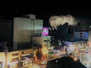 - une ville la nuit avec des feux d'artifice dans le ciel dans l'établissement SEVEN Building / Vacation STAY 4959, à Asahikawa