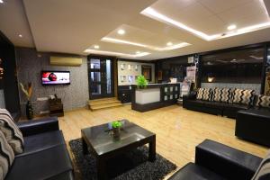 a living room with a couch and a table and a tv at Chetinaad Courtyard Gandhipuram by Centre Park in Coimbatore