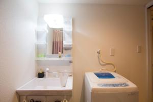 W łazience znajduje się umywalka, toaleta i lustro. w obiekcie SEVEN Building / Vacation STAY 4946 w mieście Asahikawa