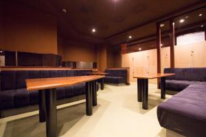 poczekalnia z dwoma stołami i niebieskimi krzesłami w obiekcie SEVEN Building / Vacation STAY 4946 w mieście Asahikawa